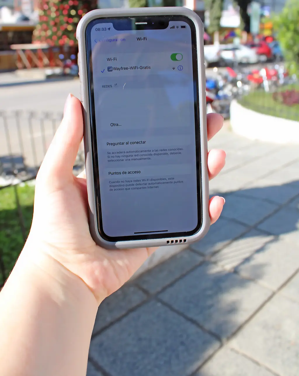 Close up photo of an iPhone screen, showing that it is connected to WiFi while in a park