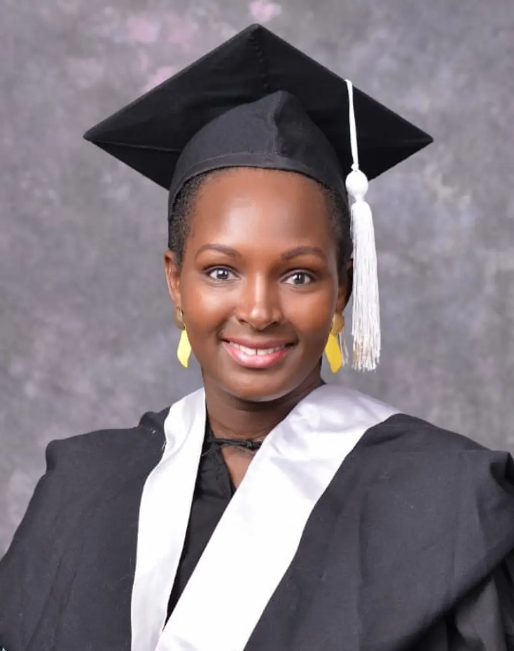 Mary Shompole, an RTI staff member based in Kenya, in a graduation cap and gown