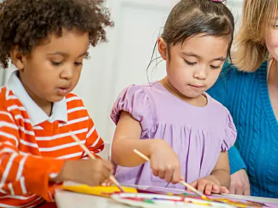 Preschool children paint with a teacher