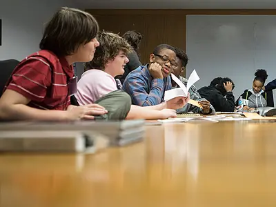 Students sit at a table for a discussion