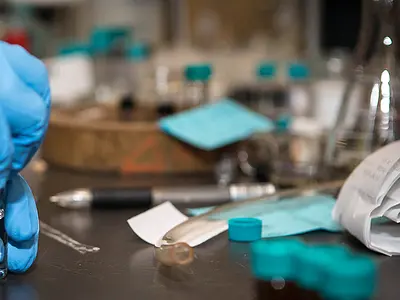 close-up of a research chemist holding a vial