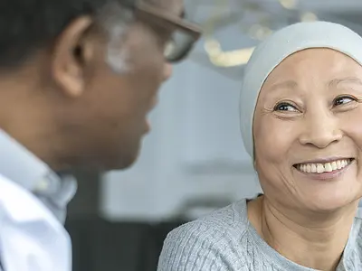 A cancer patient smiles at her doctor.