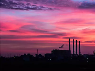 A landscape at sunset with a factory