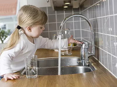 Child filling up glass with water