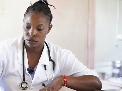 Kenyan doctor updates patient notes in her office