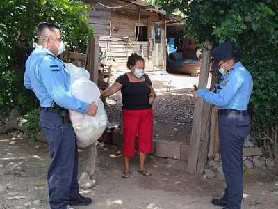 Police officers in Honduras hand out bags of groceries as part of a COVID-19 relief effort.