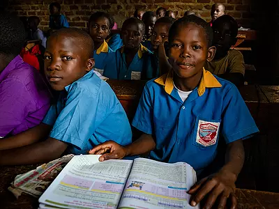 African students wearing school uniforms in a classroom.