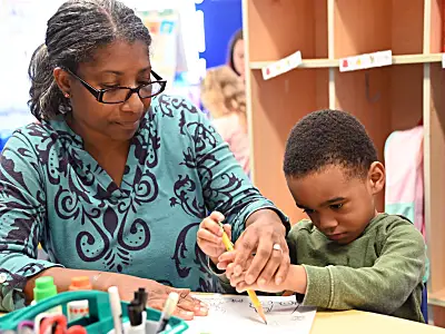 female educator helping elementary student