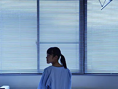 teen sitting on hospital bed in ward