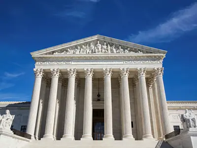 Photo of the United States Supreme Court building with blue sky in the background