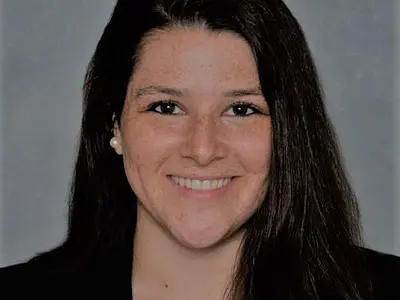 Headshot of Allyson Corbo smiling against a grey background