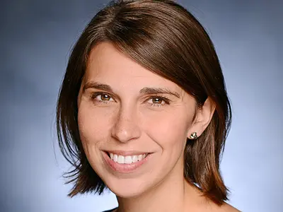 Headshot of Heather Danysh smiling against a blue background