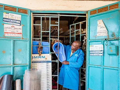 A sanitation worker in Kenya demonstrates equipment.