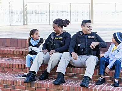 Photo of two police officers smiling with children