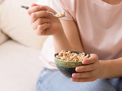 Closeup photo of a woman's hands holding bowl with Cheerios