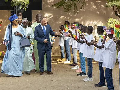 Schoolchildren in Senegal greet officials from the Ministry of Education.