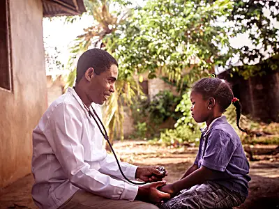 Photo of a doctor taking the pulse of a child