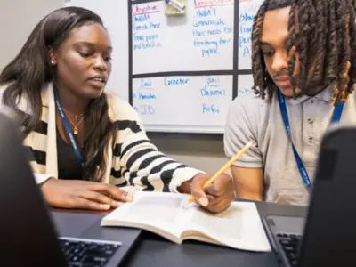 Female teacher teaching male teenage student