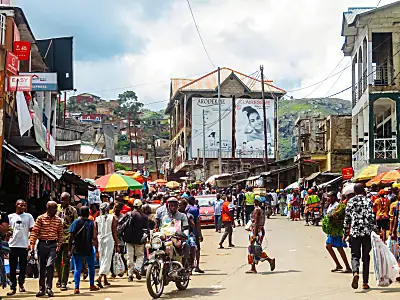 A busy street with people walking, on scooters, or in a car