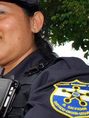 A Salvadoran law enforcement officer uses a mobile phone to report an incident