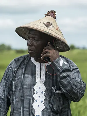 Photo of a Senegalese farmer on a cell phone in the field.
