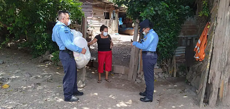 Police officers in Honduras hand out bags of groceries as part of a COVID-19 relief effort.