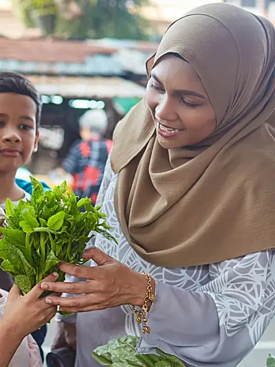 A family buying vegetables at an outdoor market