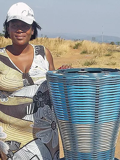 south african woman shows basket while holding cell phone