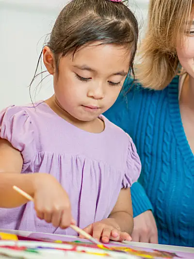 Preschool children paint with a teacher