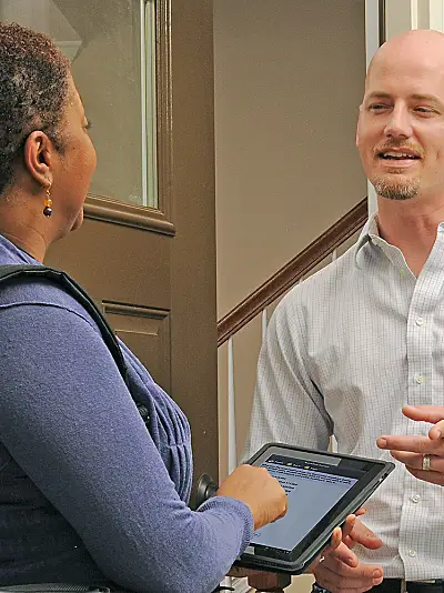 A researcher interviews a man at his home