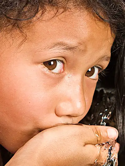 A child in Nepal drinks water