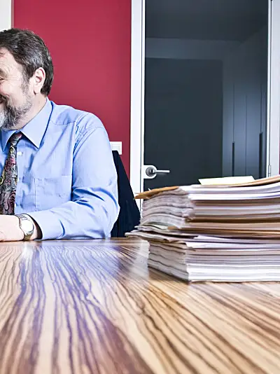 two people review documents in a conference room