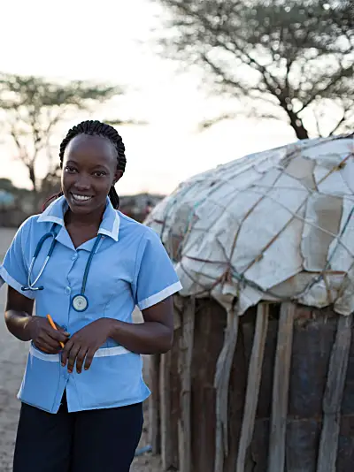 Two African nurses in a village smiling