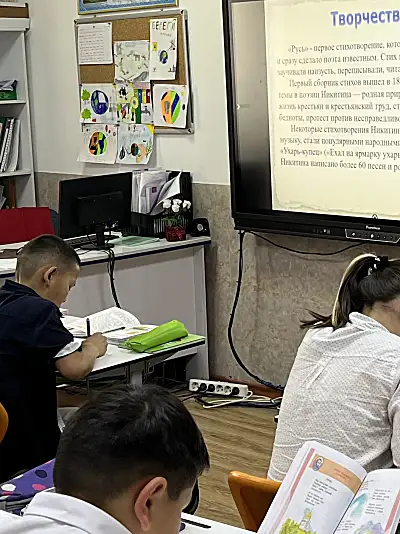 Students take notes while listening to a teacher in the Kyrgyz Republic.