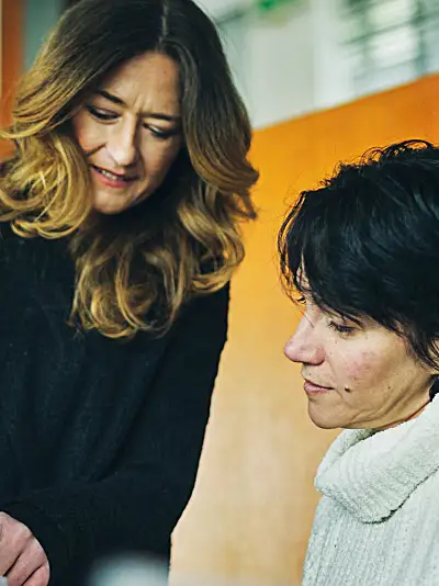 Two women consulting over paperwork