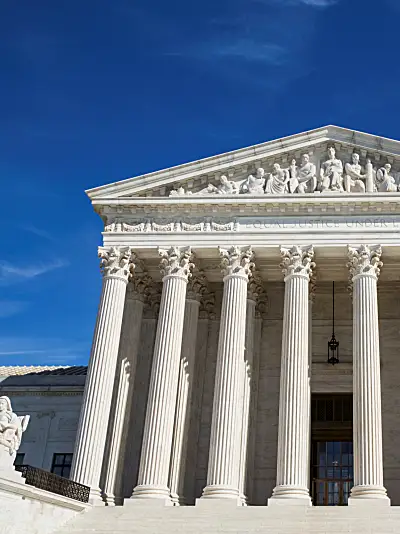 Photo of the United States Supreme Court building with blue sky in the background