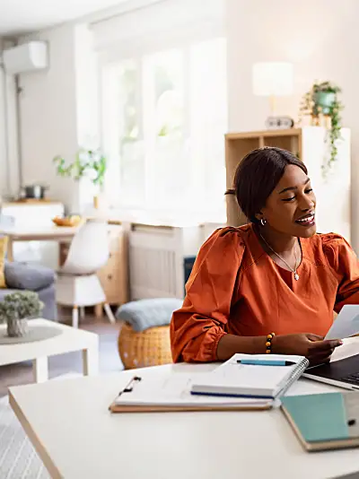 Photo of a smiling Black woman having a virtual meeting on a laptop