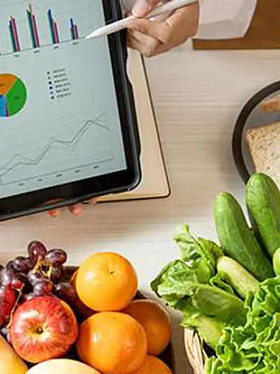 Nutrition graphs on an iPad with various healthy foods in the background