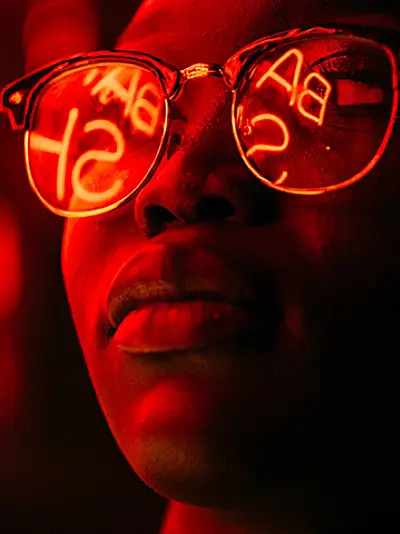 Person with glasses looking at an illuminated sign