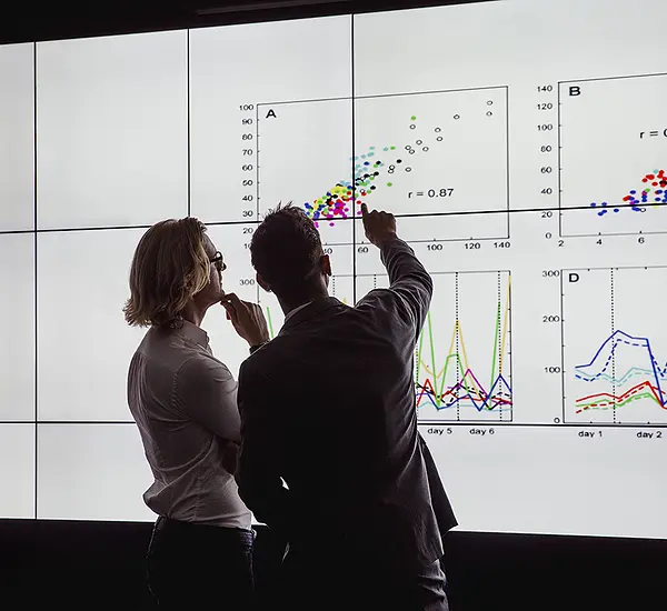 People reviewing data on a wall-sized chart.