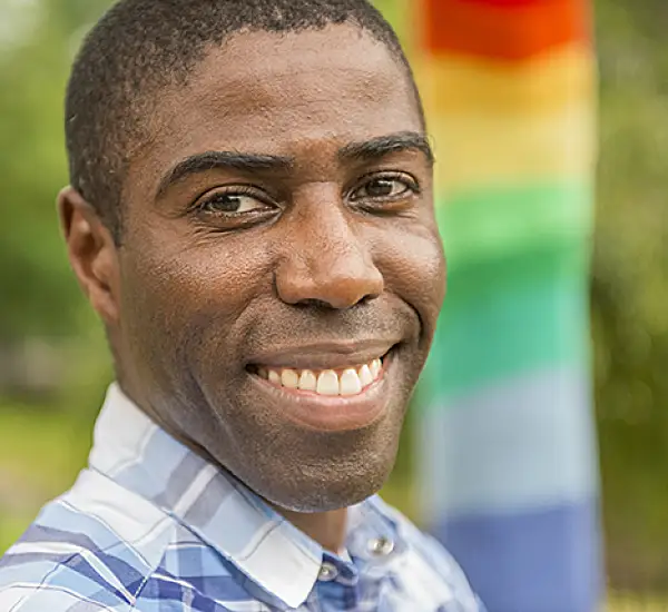 Gay man with Pride flag in the background