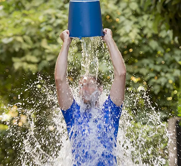 Man pours bucket of ice water over his head as part of ice bucket challenge