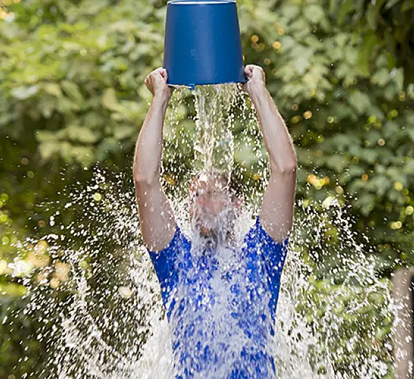 Man pours bucket of ice water over his head as part of ice bucket challenge