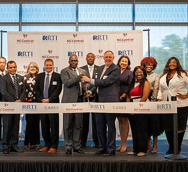 A group of people participate in a ribbon-cutting ceremony for NC Central University.