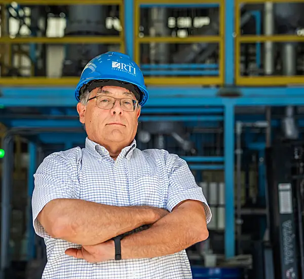 David Dayton wearing an RTI-branded hard hat with his arms crossed