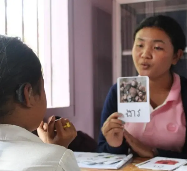 A teacher works with a girl in the Cambodia All Children Learning program.