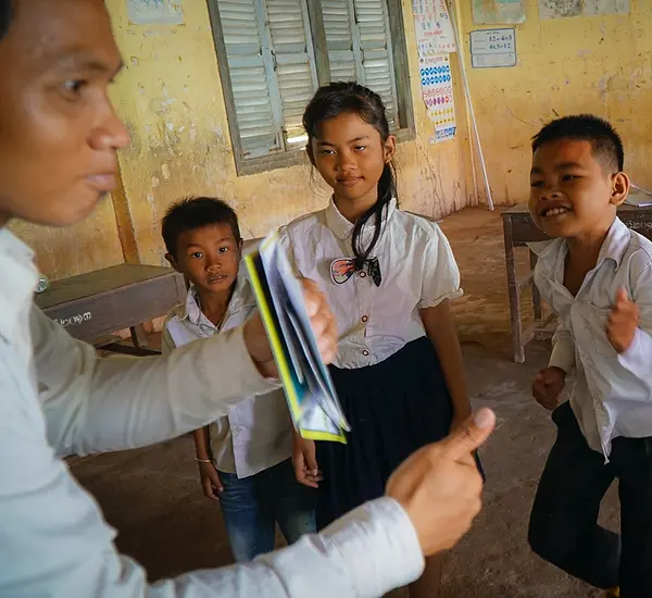 A teacher in Cambodia works with students.