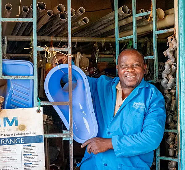 Photo of a Kenyan grocery store owner smiling