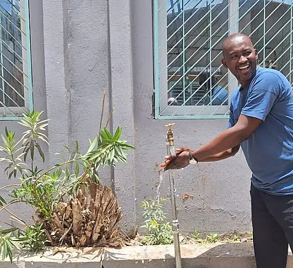 Photo of a man smiling in front of a building in Senegal