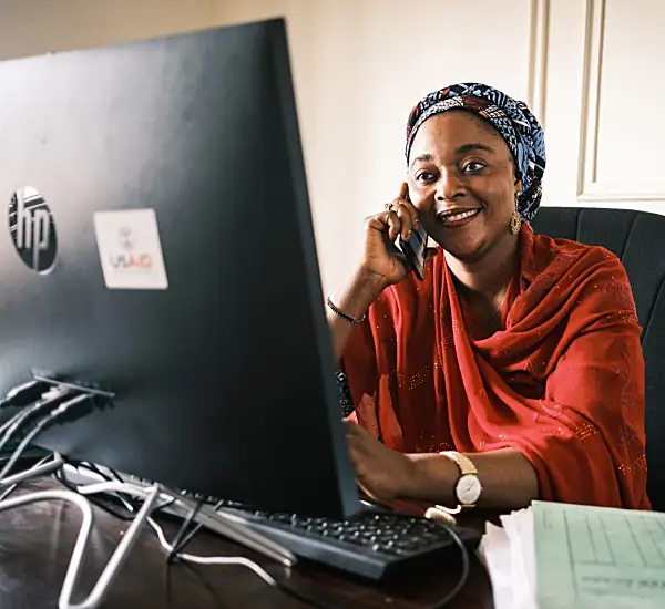 Photo of a Nigerian woman smiling in front of a computer